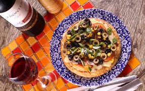 Итальянская пицца с оливками на столе с вином