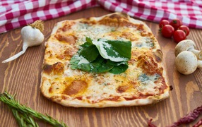 Румяная пицца на столе с овощами