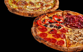 Две аппетитные пиццы на черном столе