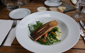 Кусок красной рыбы с овощами на столе в ресторане