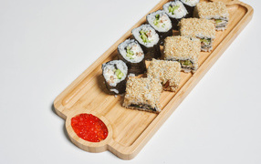 Sushi with red caviar on a cutting board