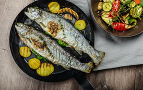 Две рыбины на сковороде с овощами