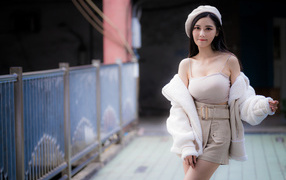 Азиатка в берете и теплой кофте на улице