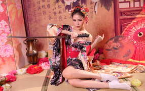 Девушка азиатка в кимоно с мечом сидит на полу 
