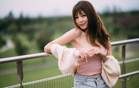 Девушка азиатка с длинными волосами у перил