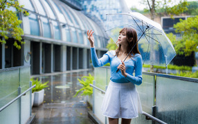 Девушка азиатка с зонтом под дождем