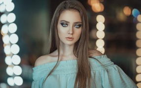 Красивая голубоглазая девушка в платье у зеркала 