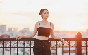 Красивая девушка в черном костюме на мосту в лучах солнца