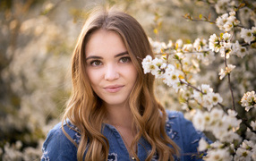Красивая девушка у ветки с белыми цветами