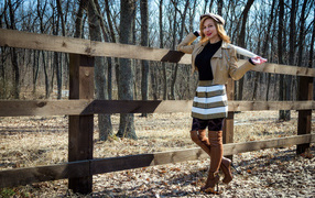 Красивая девушка стоит у забора на ферме