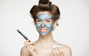 Красивая девушка с косметической маской на лице