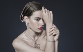 Красивая девушка с украшениями на теле на сером фоне