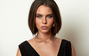 Красивая серьезная брюнетка на сером фоне