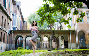 Красивая стройная азиатка на фоне здания