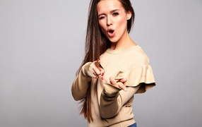 Яркая длинноволосая девушка на сером фоне 