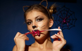 Девушка кошка с красным бантиком во рту 