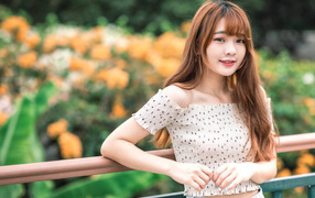 Милая девушка азиатка стоит у перил