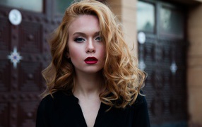 Милая блондинка с красными губами у дома