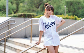 Симпатичная молодая азиатка стоит у перил