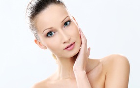 Нежная голубоглазая девушка без макияжа на белом фоне