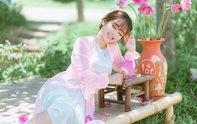 Мечтательная девушка азиатка с цветами лотоса