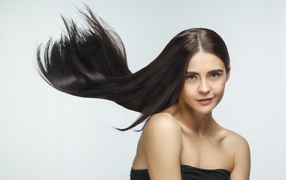 Длинные шелковистые волосы молодой брюнетки 