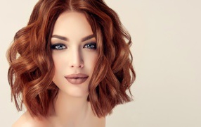 Рыжеволосая голубоглазая девушка на сером фоне