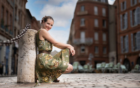 Улыбающаяся девушка в платье на улице города