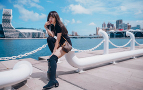 Молодая азиатка сидит в порту 