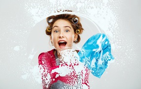 Молодая девушка в бигудях моет окно