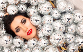 Молодая девушка усыпана блестящими шарами