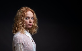 Молодая рыжеволосая девушка на черном фоне