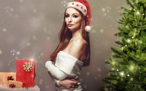 Красивая девушка с подарками у елки 