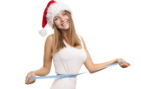 Стройная девушка в новогодней шапке на белом фоне