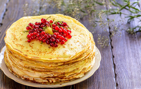 Thin pancakes with red currant berries for Shrovetide