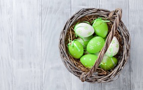 A basket of green eggs on the table for Easter