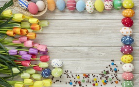 Beautiful multicolored easter eggs with a bouquet of tulips