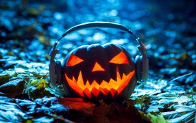 Lantern pumpkin in headphones on the ground for Halloween