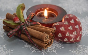 Корица, свеча и сердце на столе 