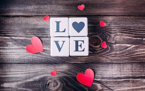 Кубики  с надписью любовь с сердечками на деревянном столе