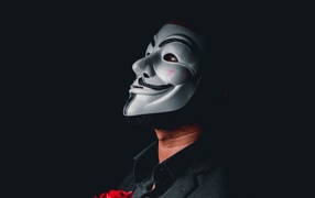 Мужчина в белой маске анонимуса на черном фоне 