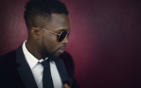 Темнокожий мужчина в костюме и очках 