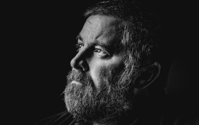 Man with gray beard on black background