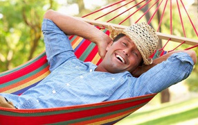 Smiling man sleeping in hammock