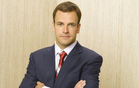 Актер Джонни Ли Миллер в костюме у стены