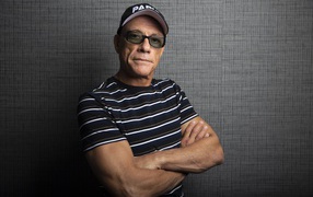 Popular actor Jean-Claude Van Damme wearing a cap against the wall