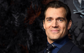 Улыбающийся актер Генри Кавилл в костюме