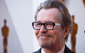 Улыбающийся мужчина, актер Гари Олдман в очках