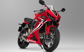 Красный мотоцикл Honda CBR 650 RR, 2021 года на сером фоне