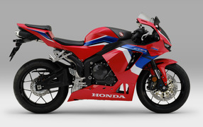 Красный мотоцикл Honda cbr600rr 2021 на сером фоне